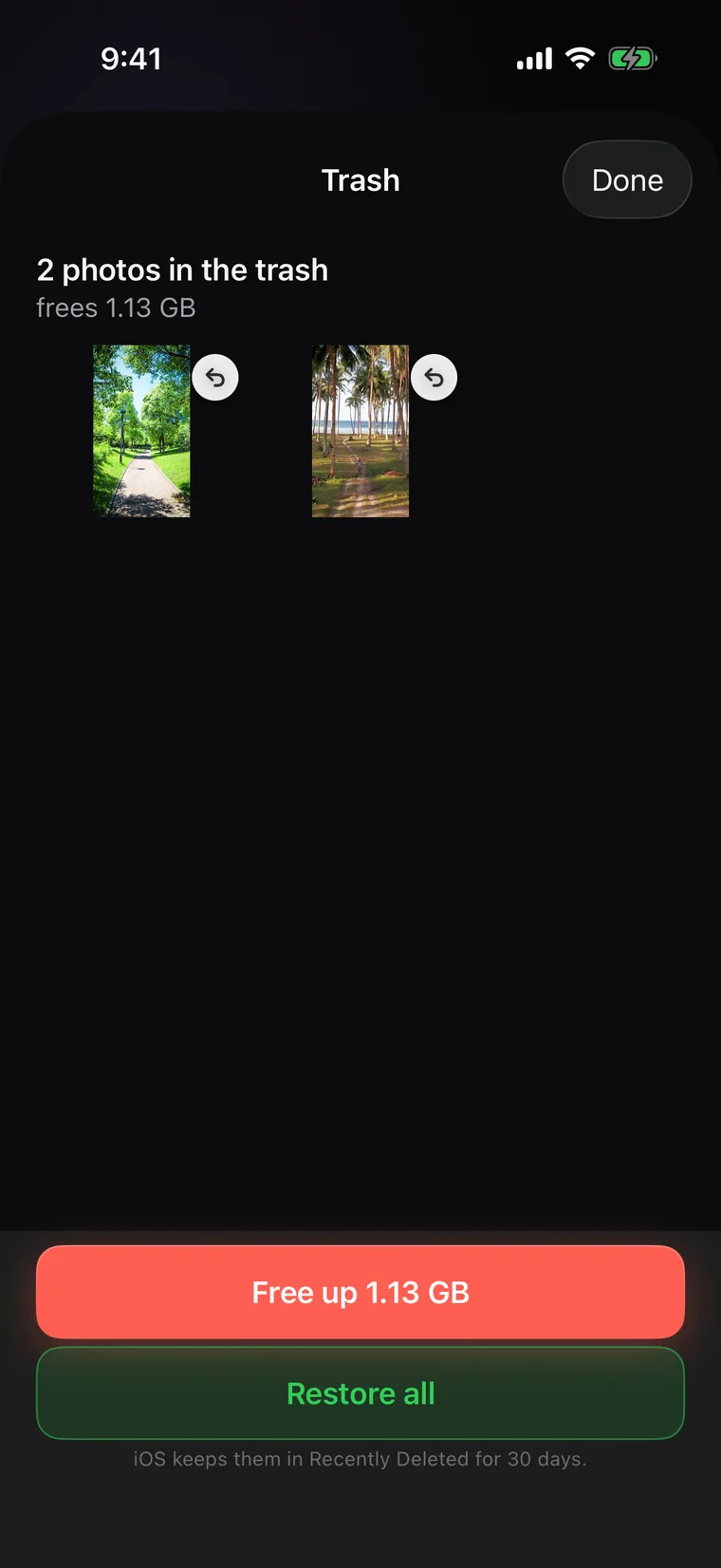 The trash: two photos waiting, with Free up in red and Restore all in green